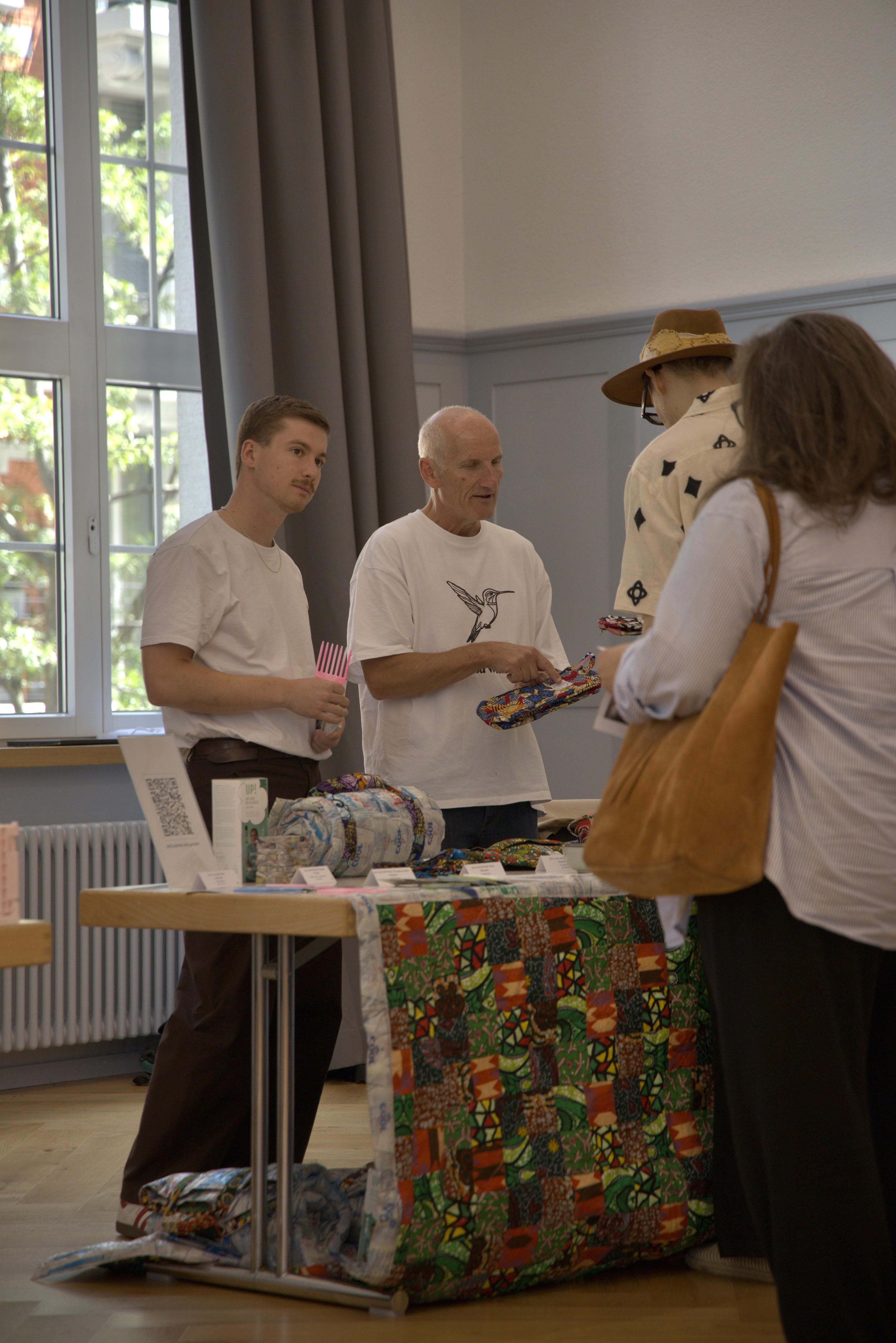 InspireDay – Bazaar, Gespräch am Stand mit afrikanischen Textilprodukten